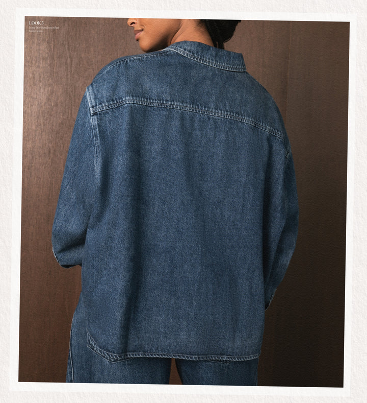 Person wearing a blue denim jacket against a brown background