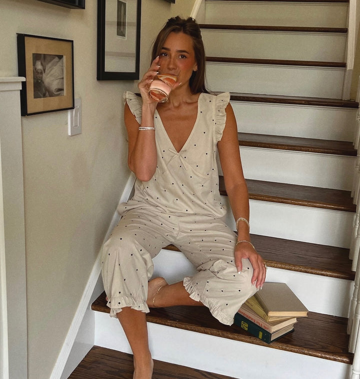 WeWoreWhat Summer 2025 Pajamas featuring Danielle Bernstein sitting on steps wearing oat colored pajamas with black polka dots